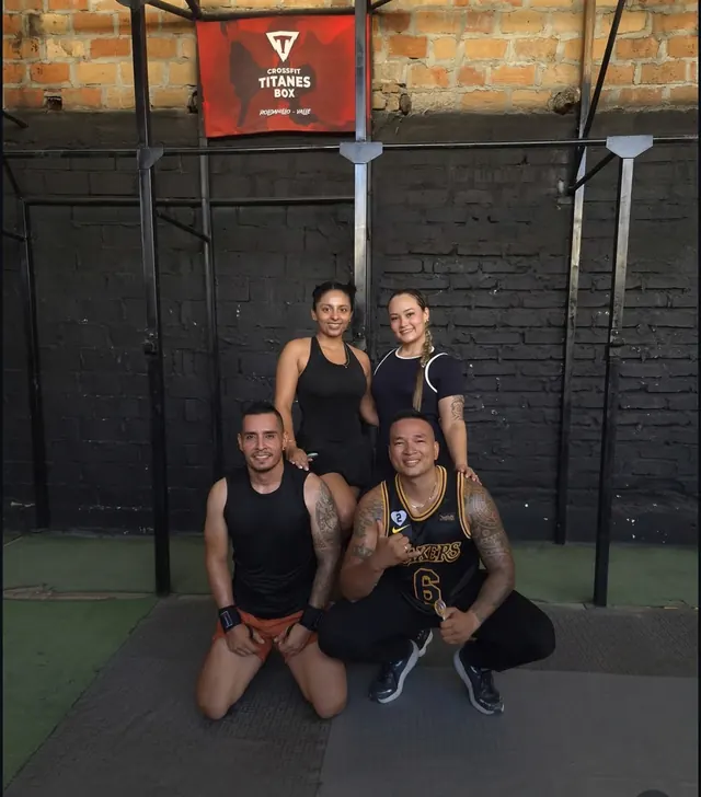 Cuatro integrantes de Titanes Box posan frente al letrero del box